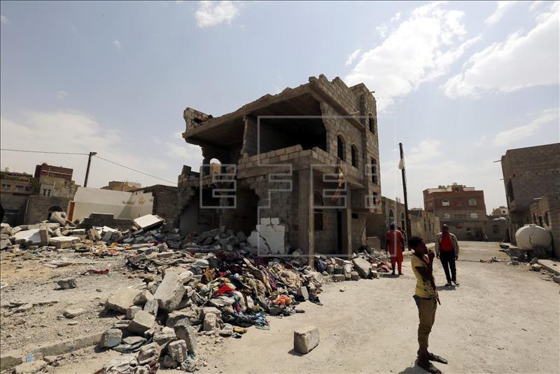 Varios yemeníes pasaban ayer por delante de un edificio destruido en uno de los bombardeos de la coalición liderada por Arabia Saudí sobre Saná. EFE