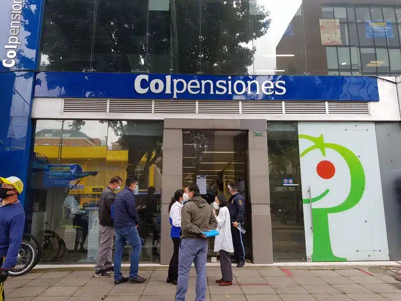 Personas esperan frente a una oficina del estatal fondo de pensiones Colpensiones en Bogotá